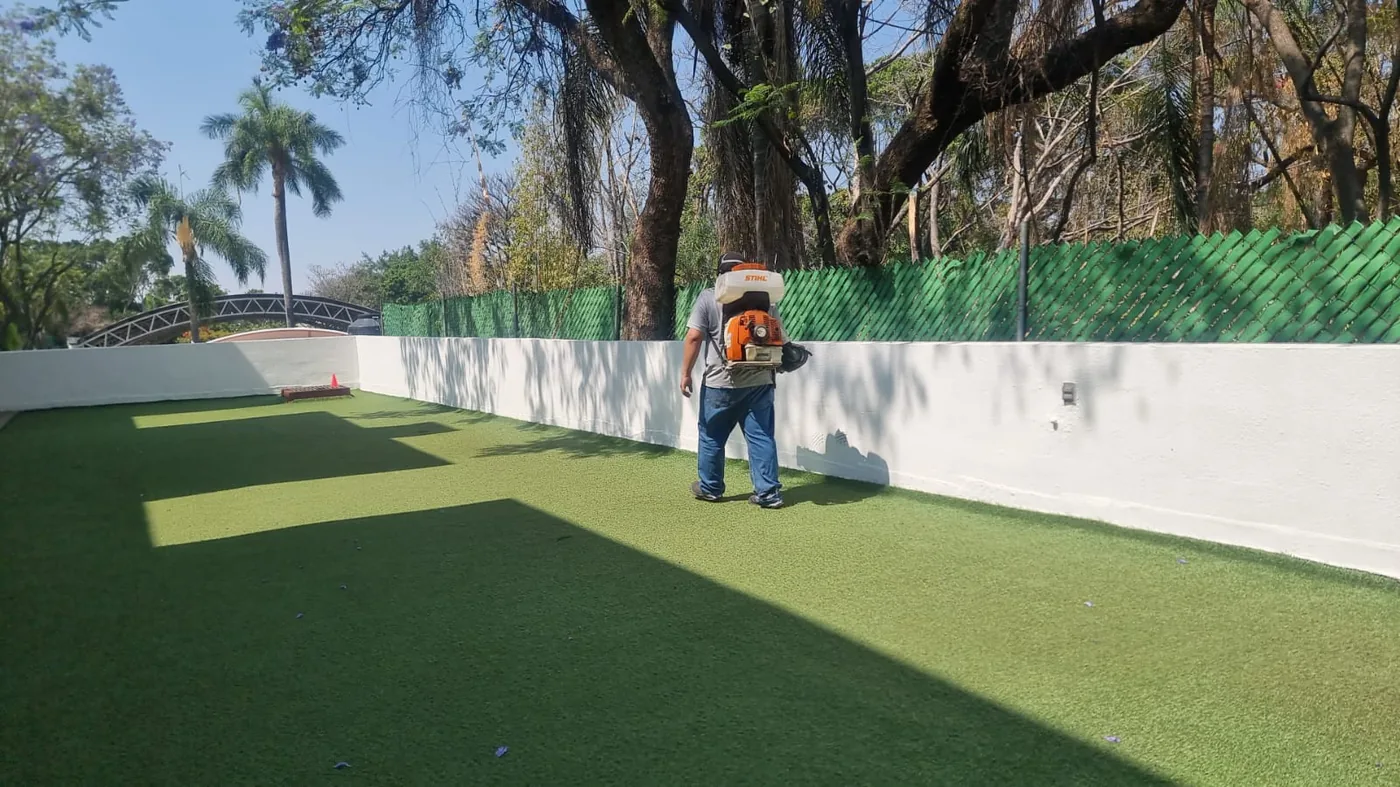 Aplicación de control de plagas en jardín residencial